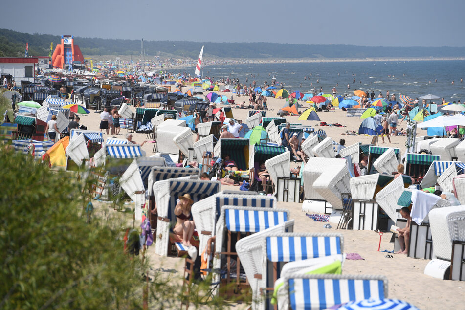 Touristen nutzen das hochsommerliche Wetter am Strand von Usedom.