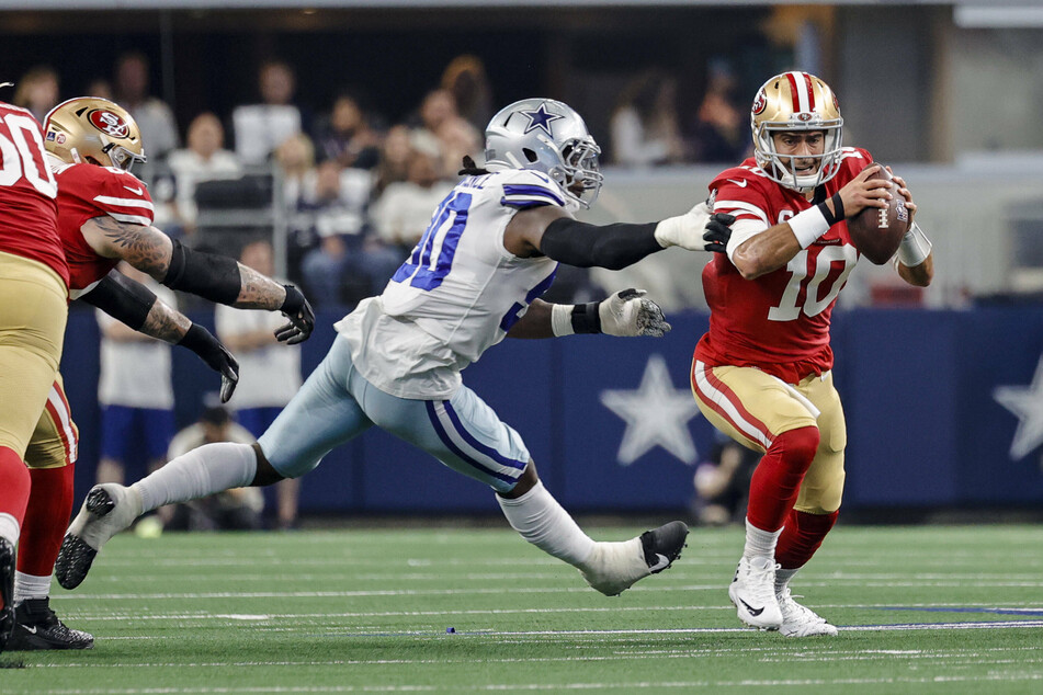 49ers quarterback Jimmy Garoppolo (r) avoids a sack during Sunday's Wild Card win over Dallas.