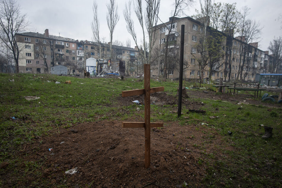 Ein Kreuz auf dem Grab eines Anwohners, der durch Beschuss getötet wurde, im Hof eines Wohnhauses in Bachmut.