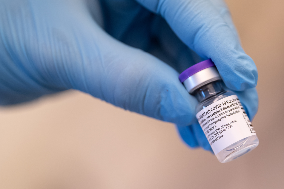 Eine medizinische Mitarbeiterin hält ein Corona-Impfstoff-Fläschchen von Biontech/Pfizer in der Hand.