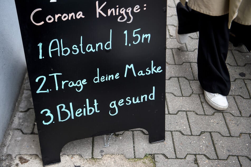 Ein Schild mit dem "Corona-Knigge" für richtiges Benehmen während der Krise in Berlin. Die Zahl der Neuinfektionen in Deutschland ist rückläufig.