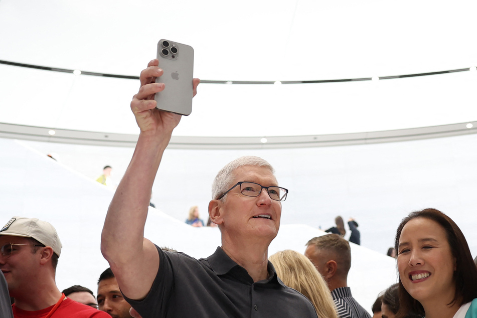 Apple-Boss Tim Cook (62) mit einem iPhone 15 in der Hand.