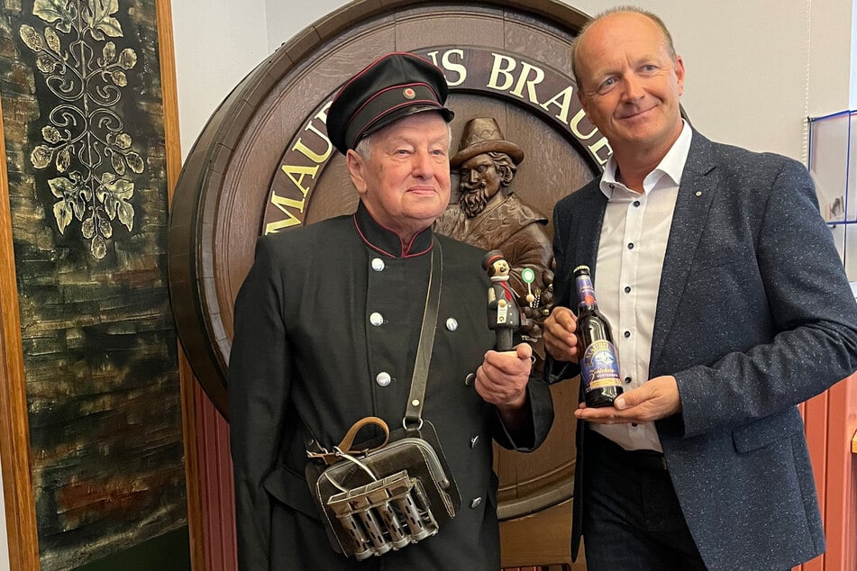 Jürgen Mattivi (l.), Vorsitzender des Vereins der Freunde des Nahverkehrs, hält sein rauchendes Abbild in der Mauritius-Brauerei Zwickau gemeinsam mit Geschäftsführer Jörg Dierig in der Hand.