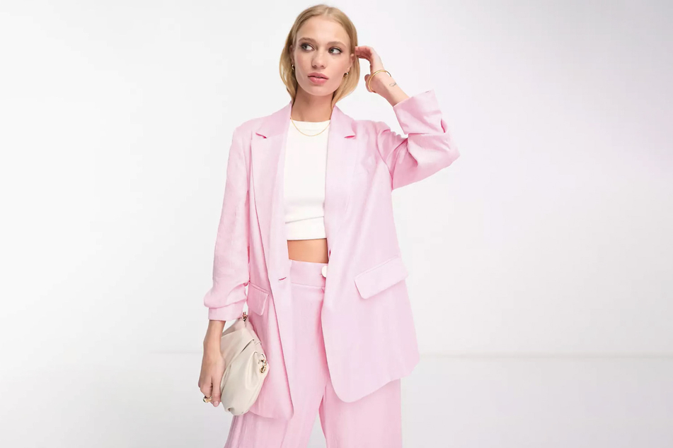 Ein rosa Blazer mit hochgekrempelten Armen sorgt für einen lässigen Look.