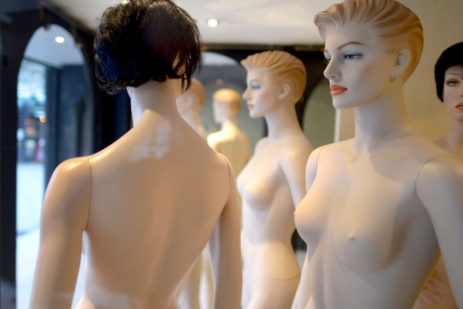 Unbekleidete Schaufensterpuppen stehen im Schaufenster eines Modegeschäftes.