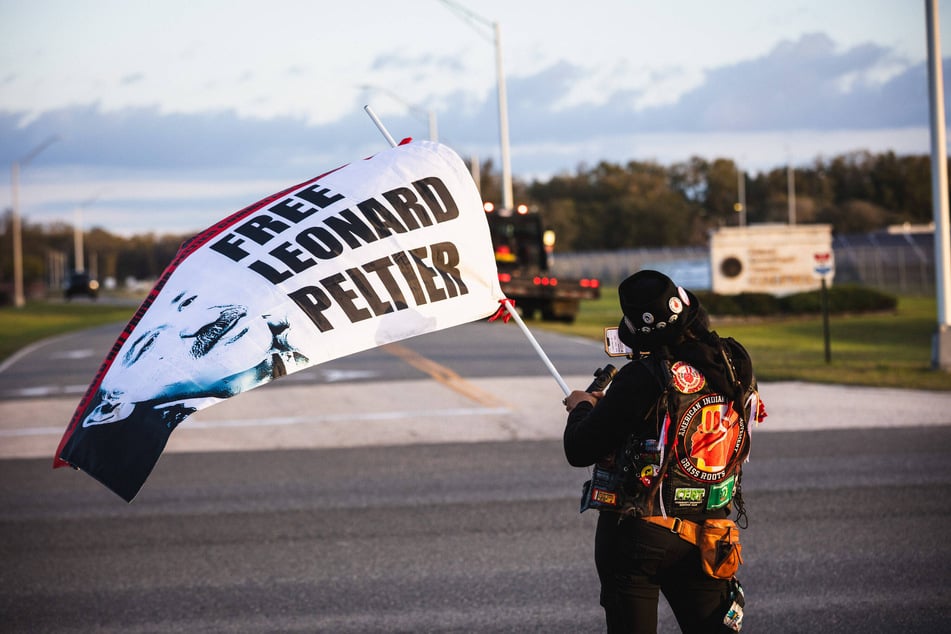 Gina Marie Rangel Quinones raises a flag outside the Coleman Federal Correctional Complex as Leonard Peltier is released from prison.