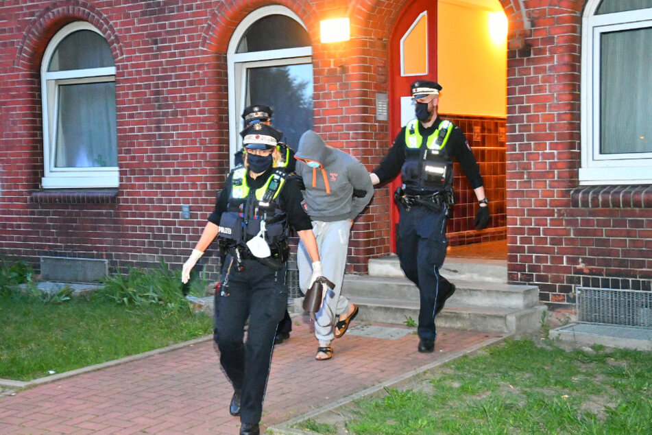 Polizisten führen den festgenommenen Mann ab.