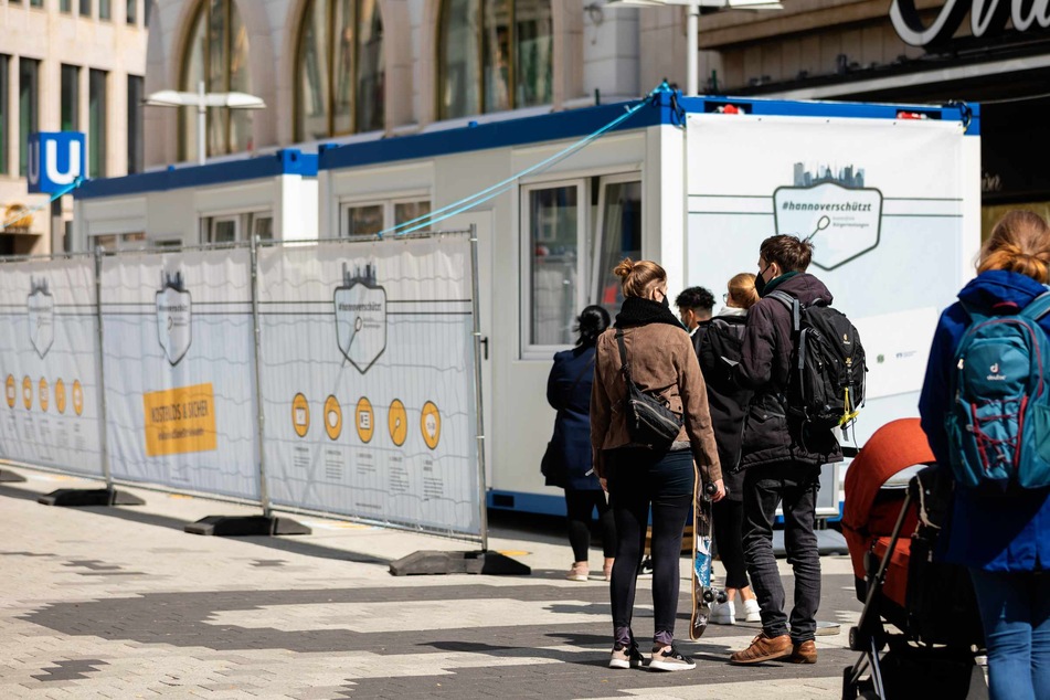 Menschen stehen vor einem Covid-19-Testzentrum.