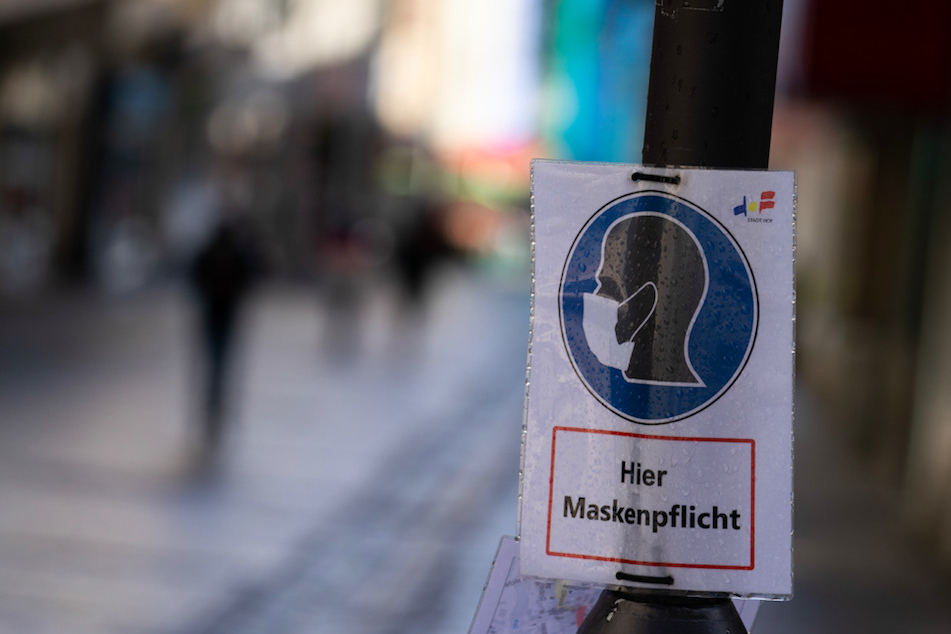 Ein Schild weist in einer bayerischen Innenstadt auf die Maskenpflicht hin.