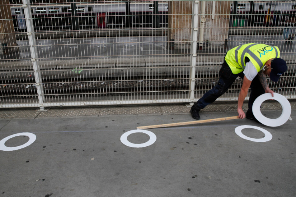 Mit dem Anbringen von Abstandsmarkierungen bereitet man sich am Pariser Gare du Nord darauf vor, die Ausgangssperre aufzuheben.
