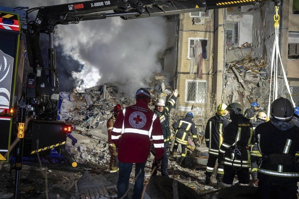 Rettungskräfte beseitigen nach dem russischen Angriff die Trümmer eines zerstörten Wohnhauses.
