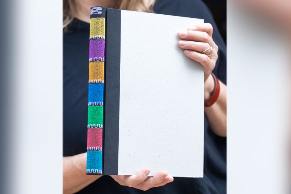 Das Deckblatt ist leer, der Buchrücken wurde in den Farben des Heizkraftwerk-Schornsteins gestaltet.