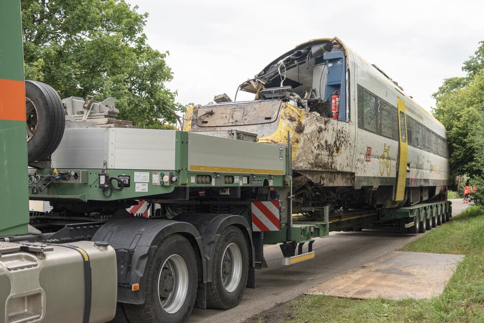 Die Fahrzeugteile werden mit einem Tieflader von der Unglücksstelle abtransportiert.