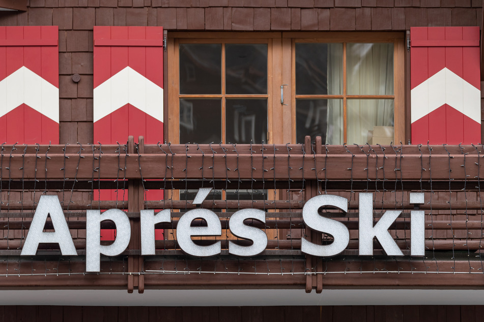 Österreich, Ischgl: Die Reklame einer Apres-Ski-Bar hängt an einem Balkon.
