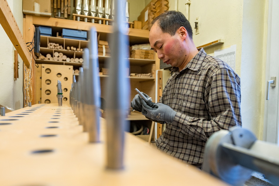 Orgelbaumeister Sangook No (45) aus Südkorea bearbeitet die Pfeifen, prüft deren Töne.