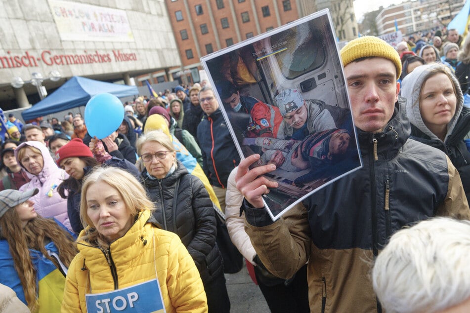 Anlässlich des zweiten Jahrestags des russischen Angriffskriegs auf die Ukraine zeigten die Demo-Teilnehmer in Köln Bilder von verletzten Zivilisten aus dem osteuropäischen Staat.