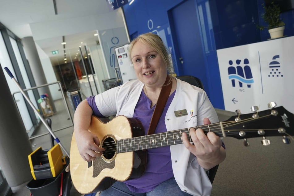 Gute Laune beim Pipi machen: Toilettenfrau greift auf dem Klo zur Gitarre