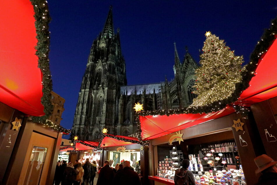 Besucher gehen über den Weihnachtsmarkt vor dem Kölner Dom. Der traditionsreiche Markt soll in diesem Jahr wegen der Corona-Pandemie ausfallen.