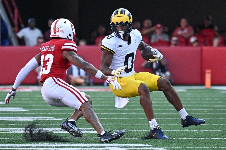 The departure of Michigan star receiver Darrius Clemons (r.) has fueled fan speculation about head coach Jim Harbaugh's potential exit.