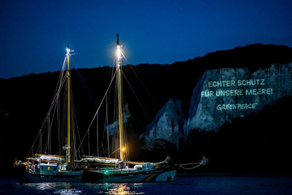 Der Schriftzug "Echter Schutz für unsere Meere" wird vom Greenpeace-Schiff "Beluga II" auf einen Kreidefelsen der Ostseeinsel Rügen projiziert.