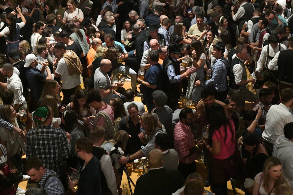 Gäste tummeln sich im Hofbräuzelt auf der Wiesn - und zwischen ihnen jede Menge Viren.