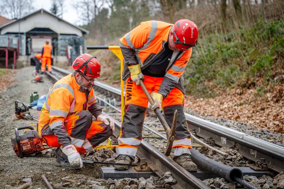 Gleisbauer Bastian Tetzlaff (r.) und seine Kollegen tauschen derzeit auf der Strecke der Drahtseilbahn Augustusburg alte Holz- gegen neue Kunststoffschwellen aus.