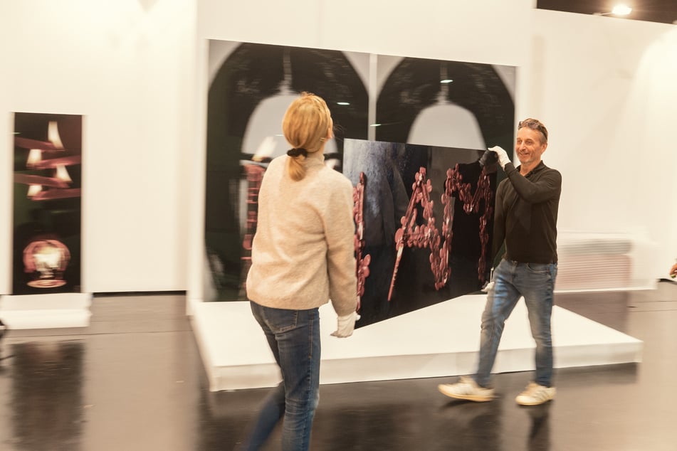 Galeristin Frieda Vogel (l.) und der Leipziger Architekt Heiko Mühle (58, r.) tragen ein Bild von Jean-Remy von Matt. Am Wochenende geht die "art &amp; style"-Messe los.