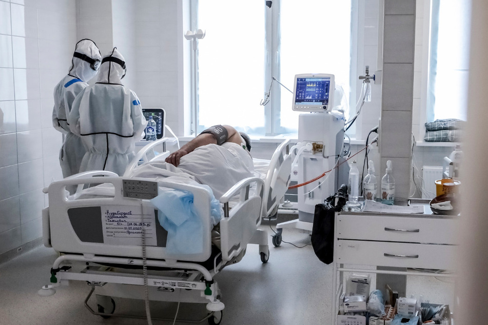 Ärzte in Schutzkleidung betreuen einen Patienten auf einer Intensivstation für COVID-19-Patienten in einem Krankenhaus in Moskau.