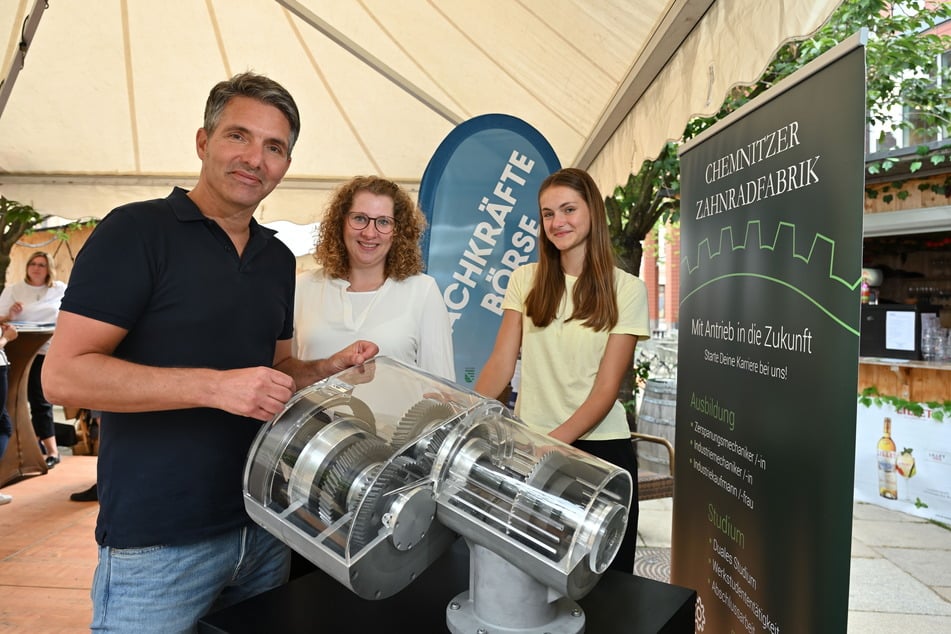 Jan Schiefer (50, v.l.n.r.), Katharina Korch (27) und Amelie Kestel (14) stehen am Stand der Chemnitzer Zahnradfabrik.