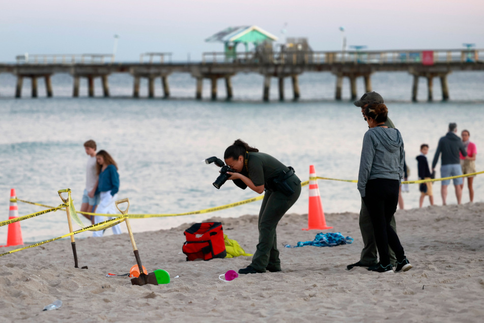 Eine Polizistin macht am Strand von Lauderdale-by-the-Sea Fotos vom Unfallort.