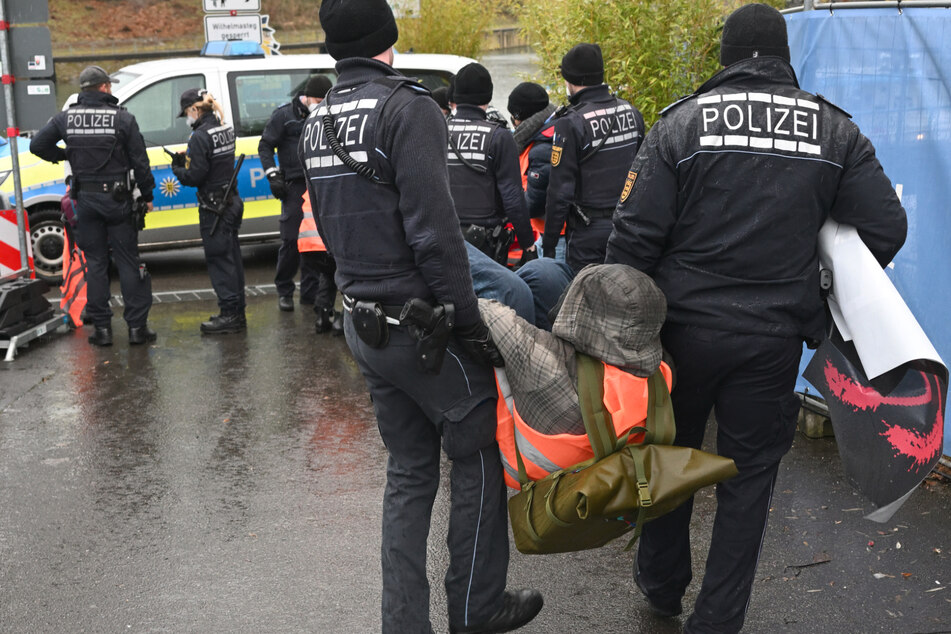 Klimaaktivisten in Stuttgart werden von Polizisten weggetragen.