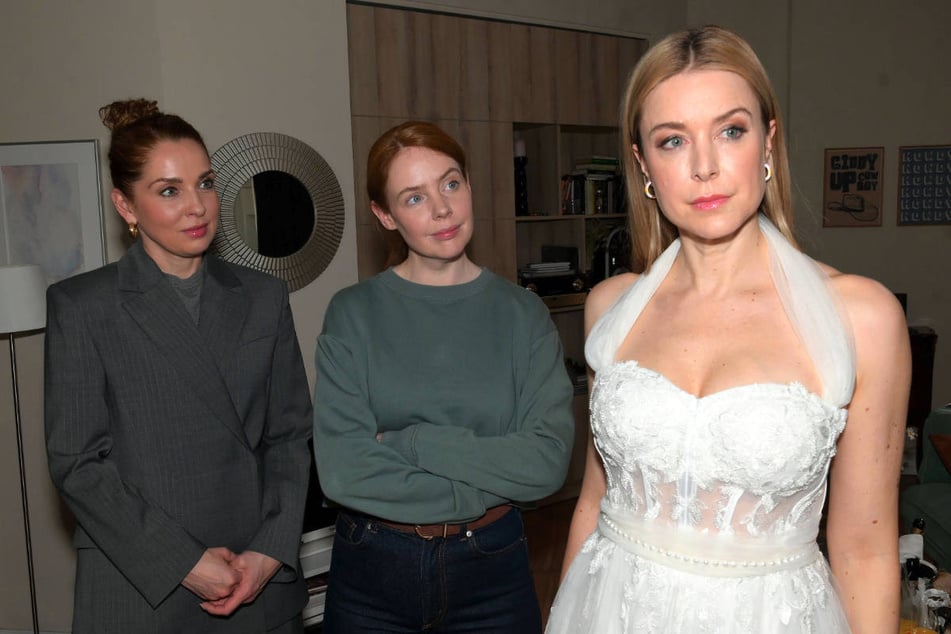 Jessica (r.) betrachtet sich skeptisch in ihrem Brautkleid – können Nina (l.) und Toni sie überzeugen?