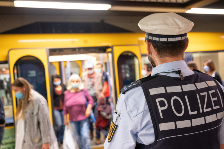 Ein Polizeibeamter kontrolliert an einer Haltestation die Einhaltung der Maskenpflicht.