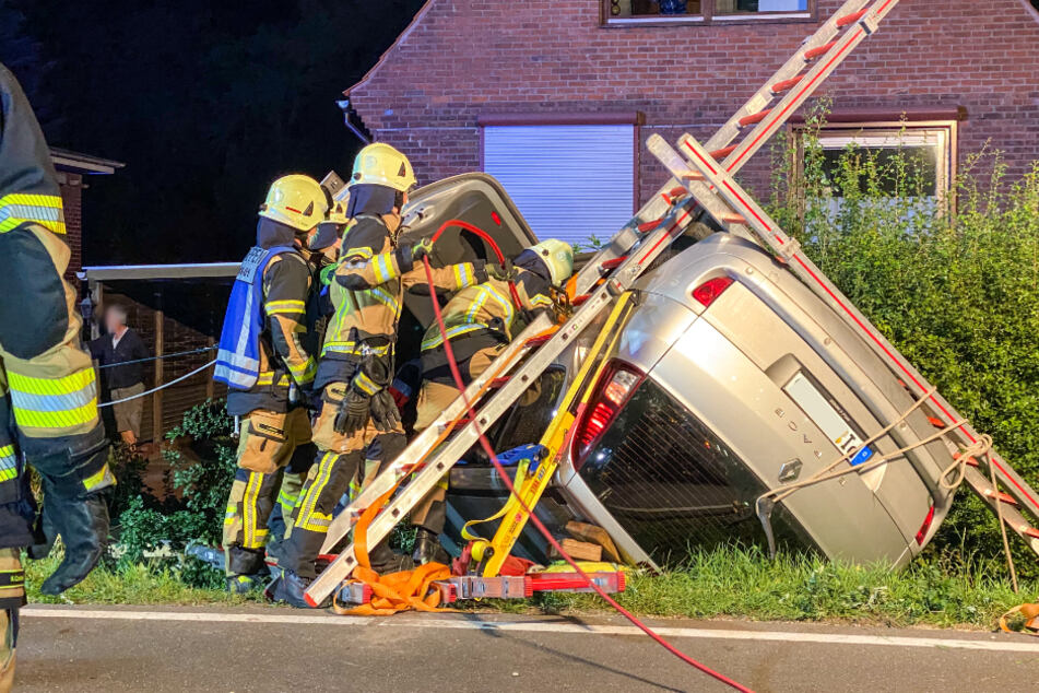 Feuerwehrleute befreien die eingeklemmte Fahrerin aus dem Wagen.