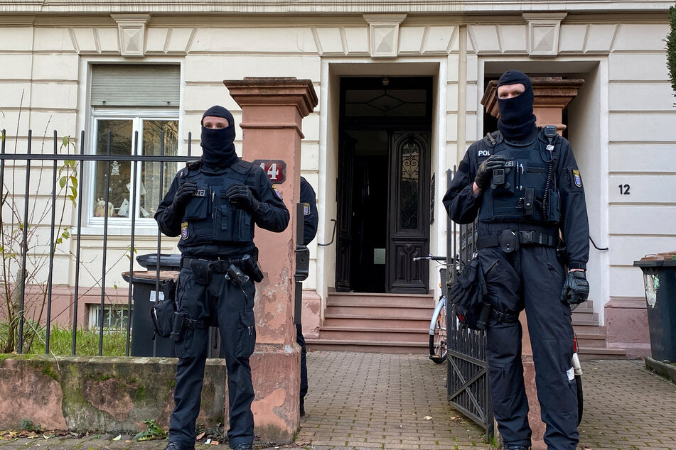 German police stand in front of a building raided in Frankfurt.