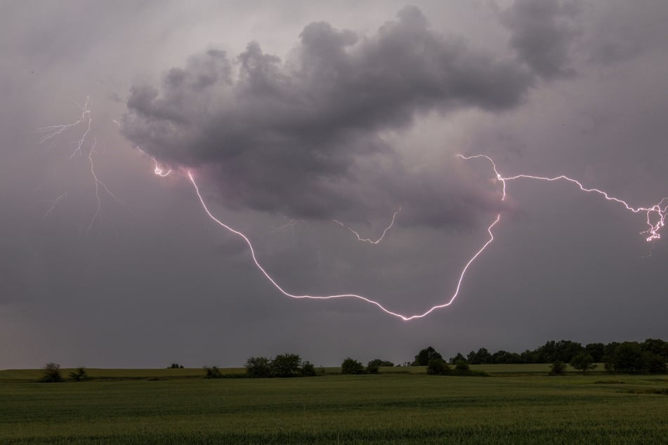 Der Blitz eines Gewitters über einem Feld bei Oberursel-Oberstedten (Hessen).