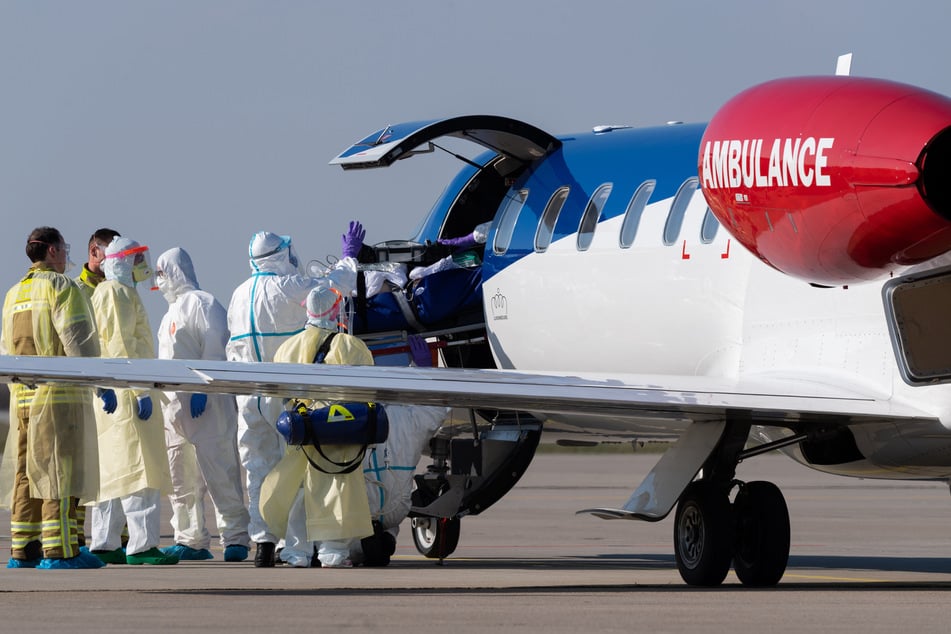Ein schwer kranker Covid-19-Patient aus Frankreich wird auf dem Flughafen Dresden International aus einem Ambulanzflugzeug in den Krankenwagen transportiert.