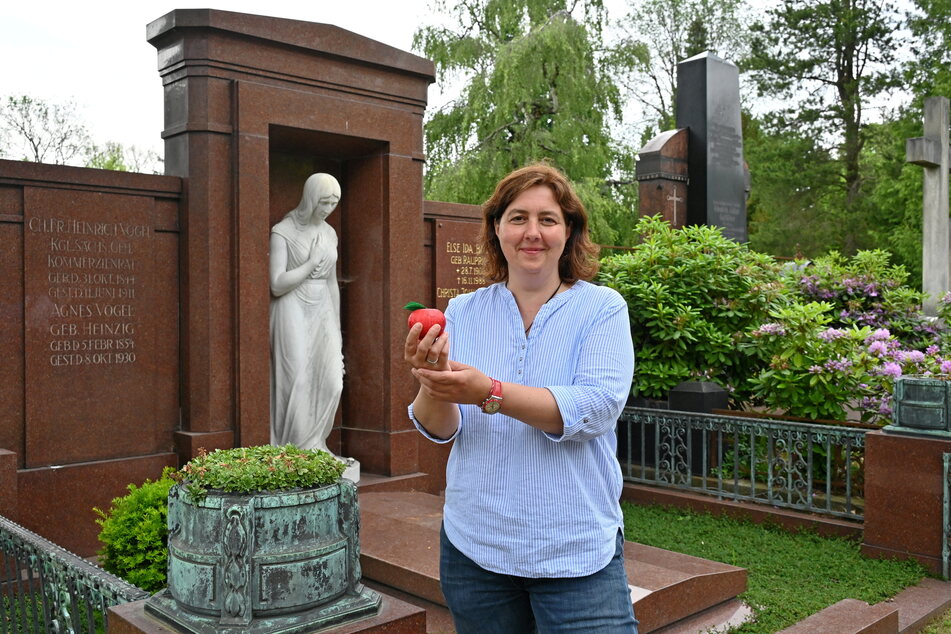 Leckereien am Grab: Verwaltungsleiterin Beatrice Teichmann (46) mit dem Tell-Apfel aus Schokolade an der Ruhestätte seines Erfinders Heinrich Vogel (1844-1911).