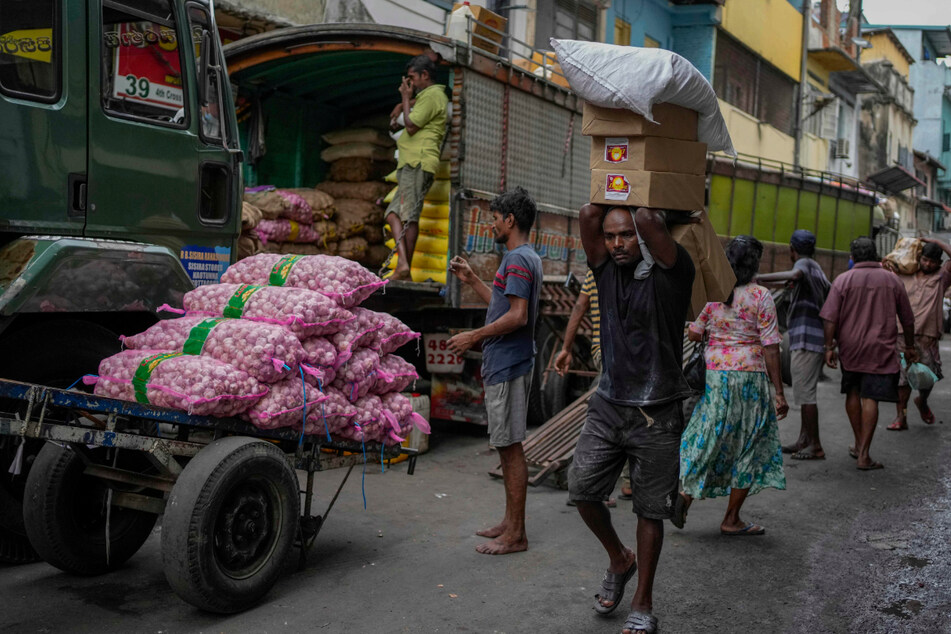 Ein Mann trägt eine Ladung importierter Lebensmittel auf einem Markt in Colombo.