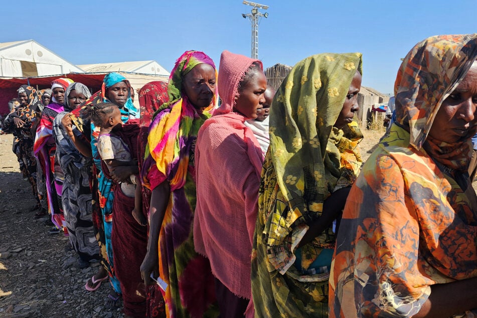 People displaced from the Heglig area in western Sudan wait to receive humanitarian aid at the Abu al-Naga displacement Camp in Gedaref State on December 30, 2025.