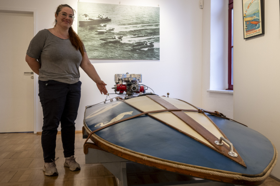 Daniela Sadowski (41), Mitarbeiterin des Rennsportmuseums, zeigt das älteste Rennboot der Ausstellung. Es wurde 1938 gebaut.