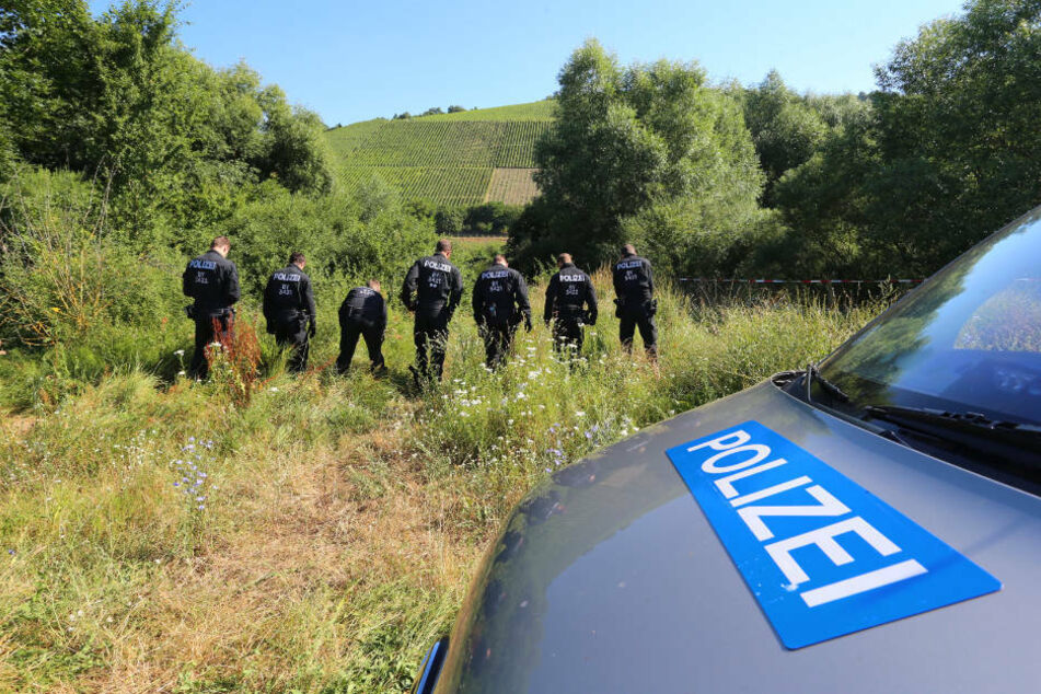 Polizisten durchsuchen im Mai 2017 neben einem Weg das Gelände nach Spuren der vermissten 16-Jährigen.