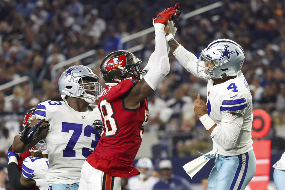 The moment of injury: Dallas Cowboys quarterback Dak Prescott (r.) hits his hand against Tampa Bay Buccaneers linebacker Shaquil Barrett (c.) while throwing during the fourth quarter at AT&amp;T Stadium on Sunday night.