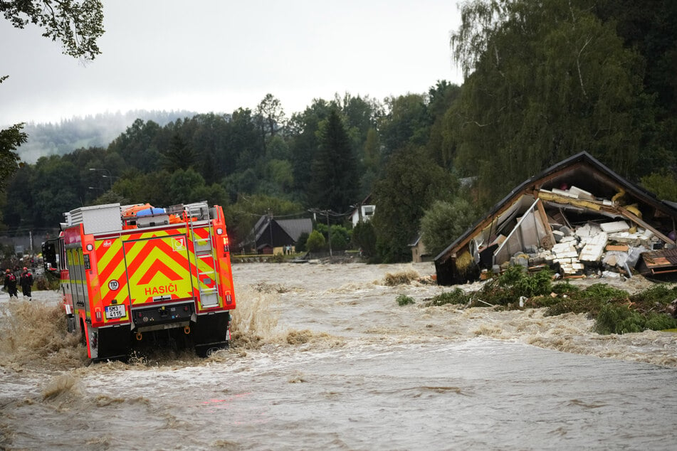 Feuerwehrleute fahren durch eine überflutete Straße. Die Hochwasserlage spitzt sich auch in Tschechien weiter zu.