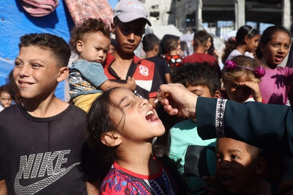 A medic administers a polio vaccine to a Palestinian child in Khan Yunis in the southern Gaza Strip on October 19, 2024.