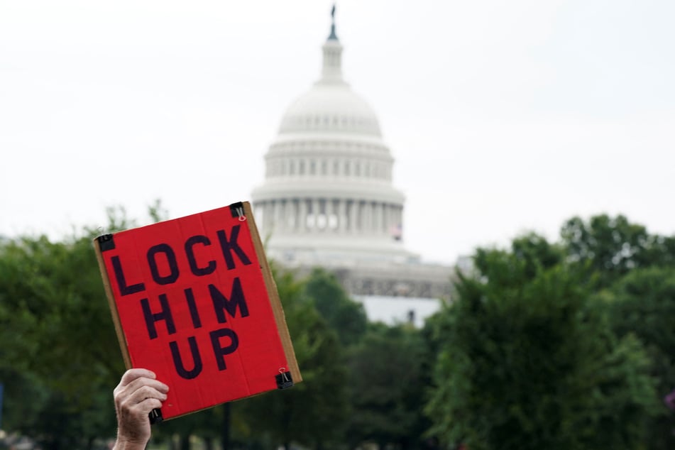 A demonstrator holds a placard reading "Lock Him Up" on the day former President Donald Trump appears at the US District Court in Washington DC.