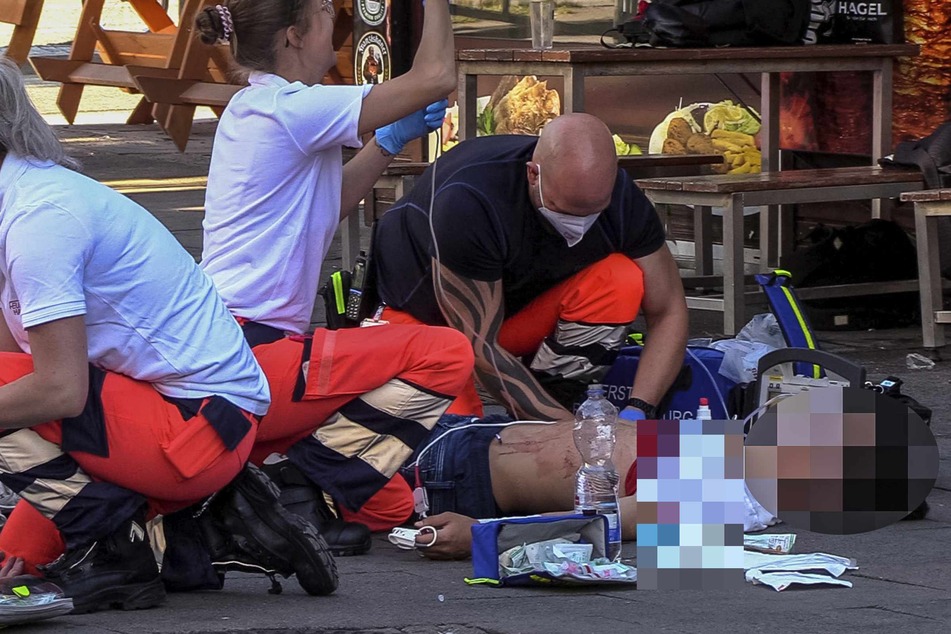 Die Rettungskräfte versorgen eines der Opfer nach der Messerstecherei.