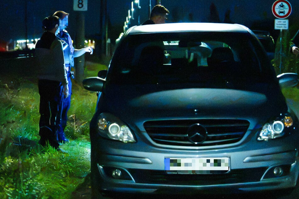 Ermittler stehen bei dem Auto des Opfers: Die Hintergründe der Attacke in Rodgau-Hainhausen sind noch völlig unklar.