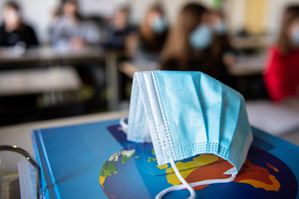 Ein Mund- und Nasentschutz liegt im Unterricht einer Gymnasium-Schulklasse.