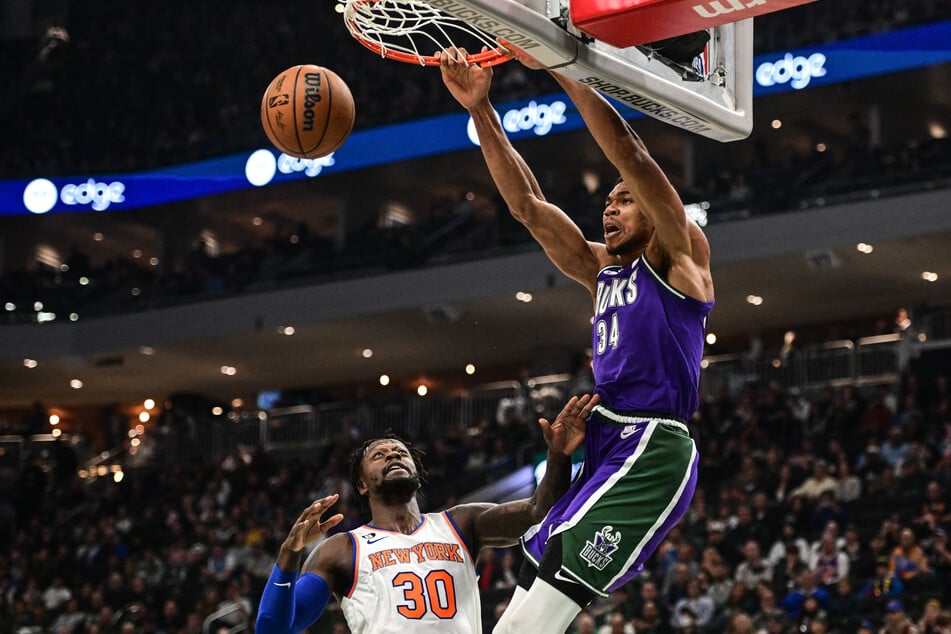 Milwaukee Bucks forward Giannis Antetokounmpo dunks over New York Knicks forward Julius Randle in the first quarter at Fiserv Forum.